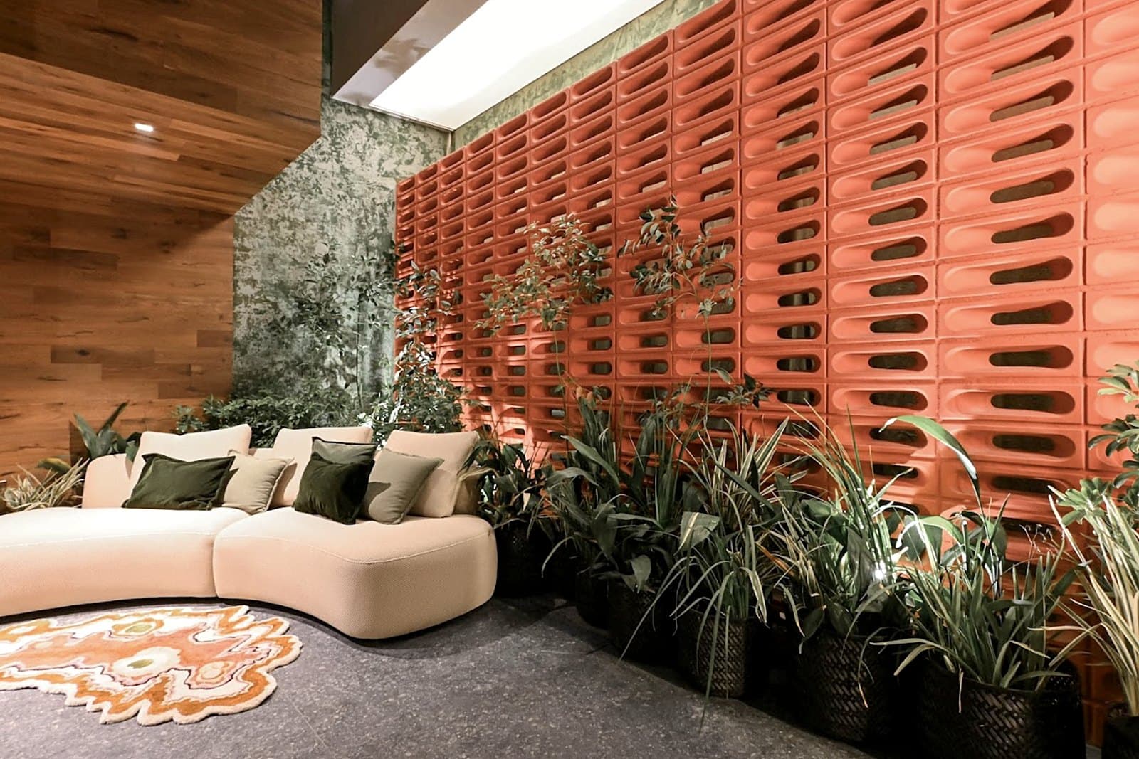 Living con muro de cobogó terracota y plantas