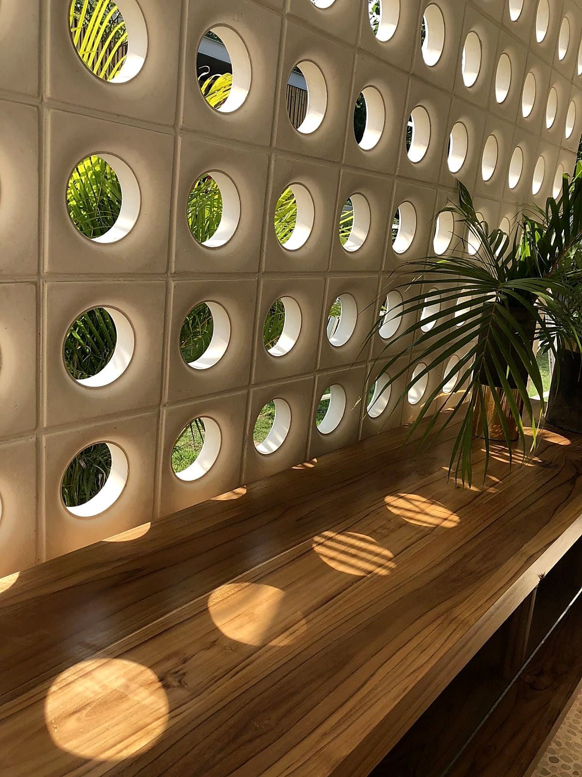 Cobogó de círculos proyectando luz sobre una mesada de madera