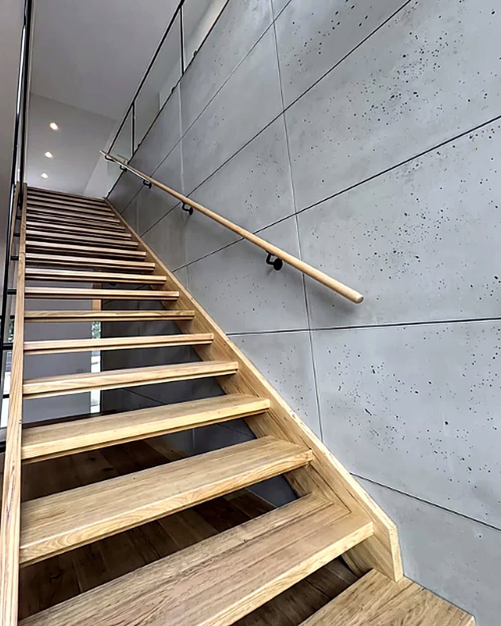 Escalera de madera junto a un muro de placas de concreto