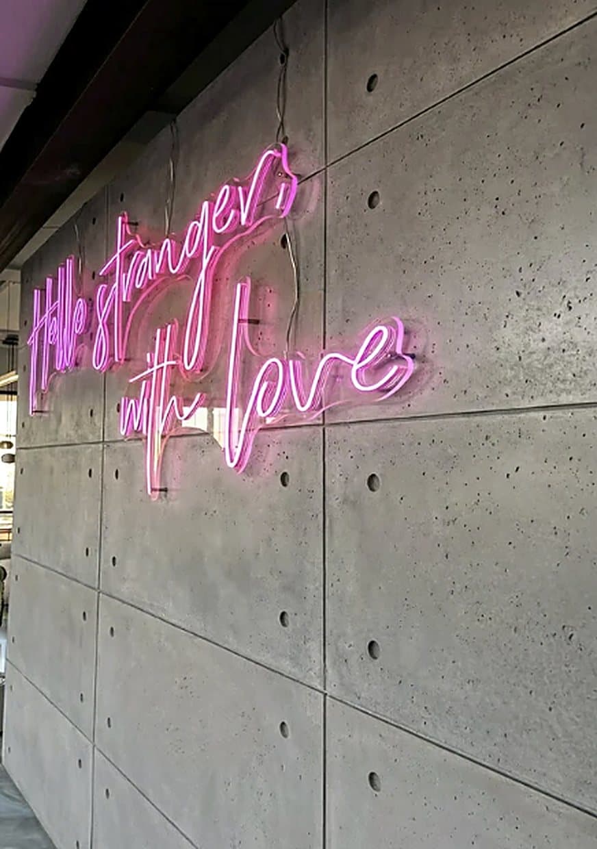 Muro de placas de concreto con un cartel de neón